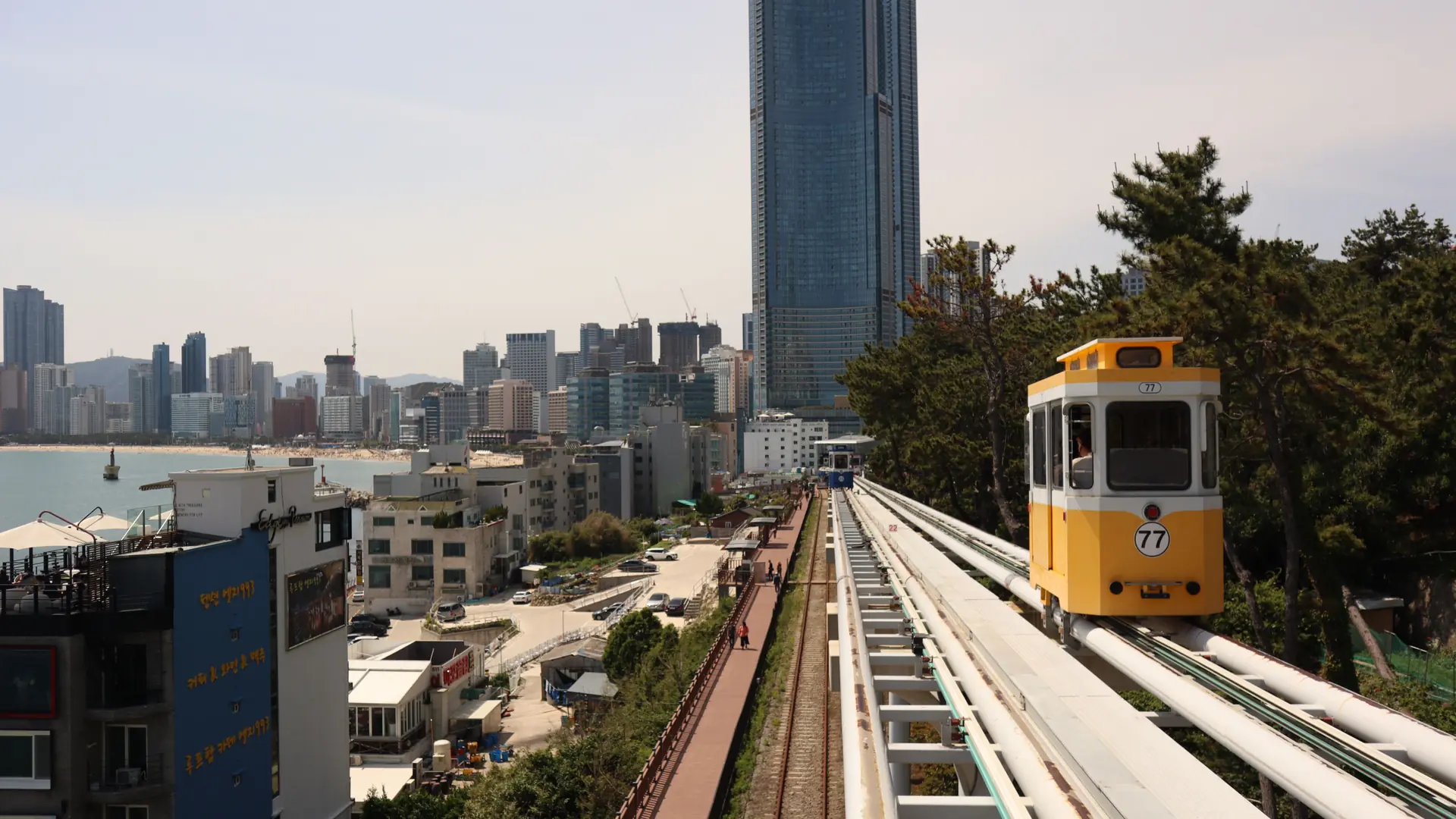 Yellow Sky Capsule near Mipo with Haeundae Beach and the LCT towers behind it in Busan