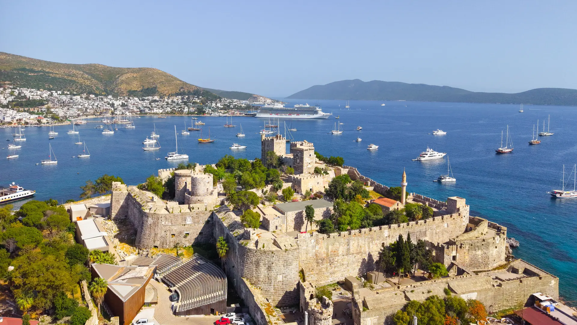 Bodrum Castle above a sunny blue Aegean harbour lined with white houses and sailing boats