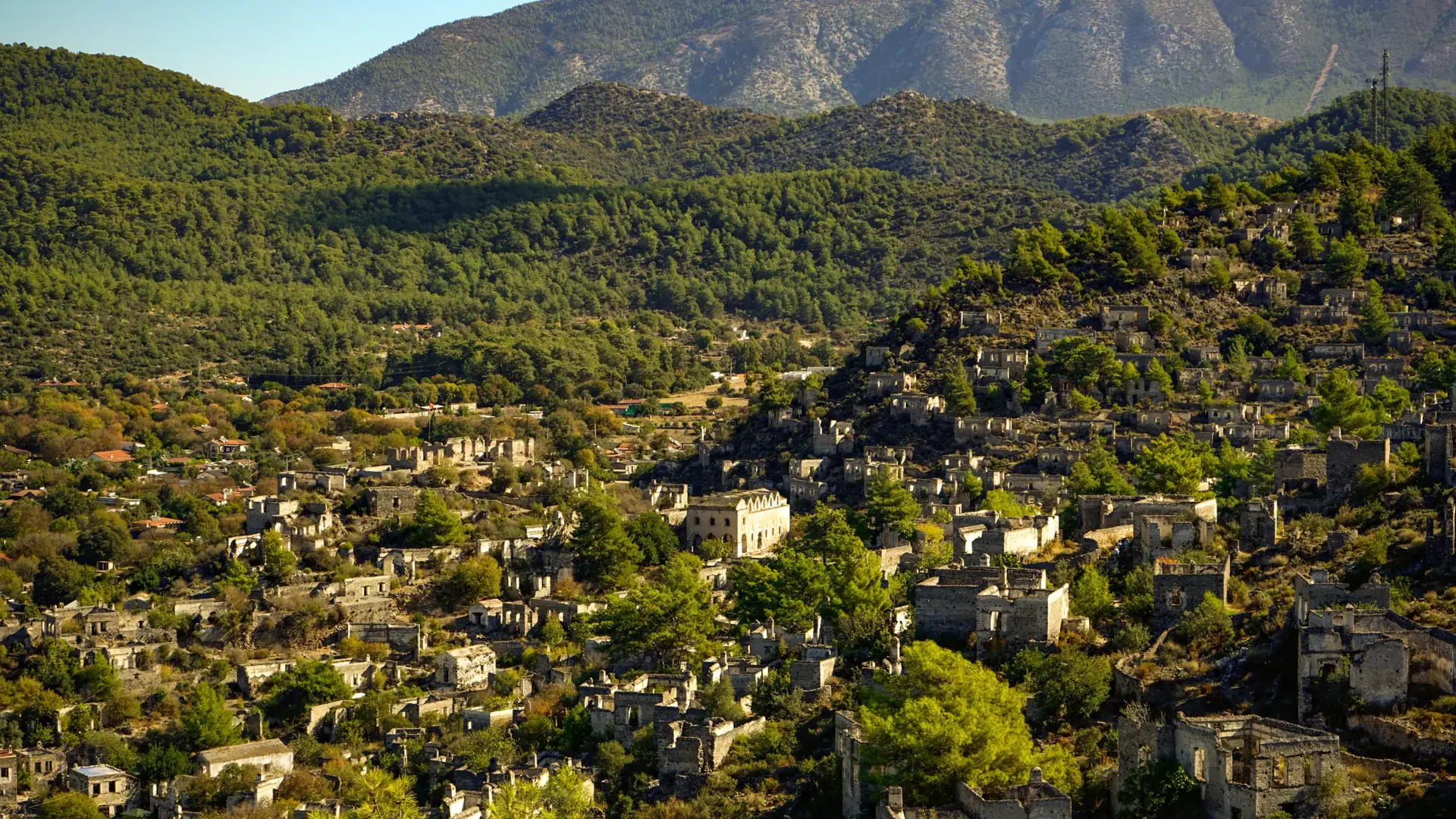 Sunlit stone houses and green valley of historic Kayaköy near Fethiye