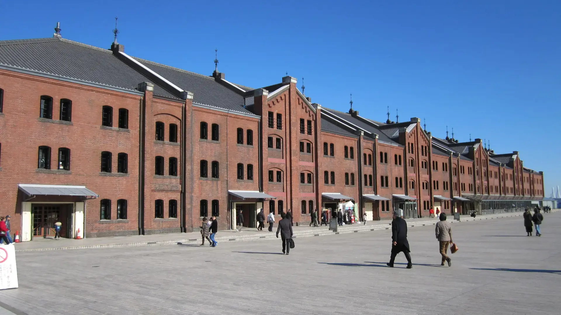 Yokohama Red Brick Warehouse glowing warm red beneath a cloudless blue sky