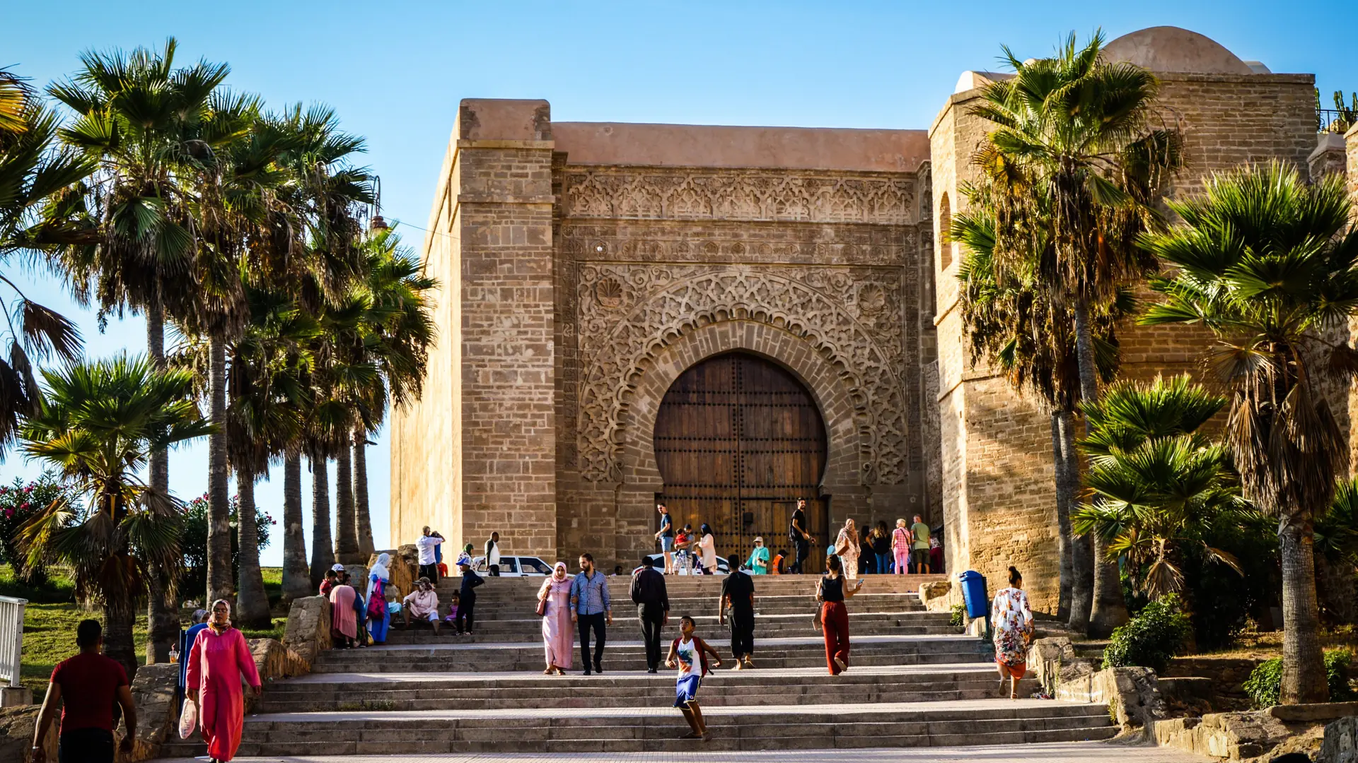 Bab Oudaia gate framed by palms and a bright Rabat sky
