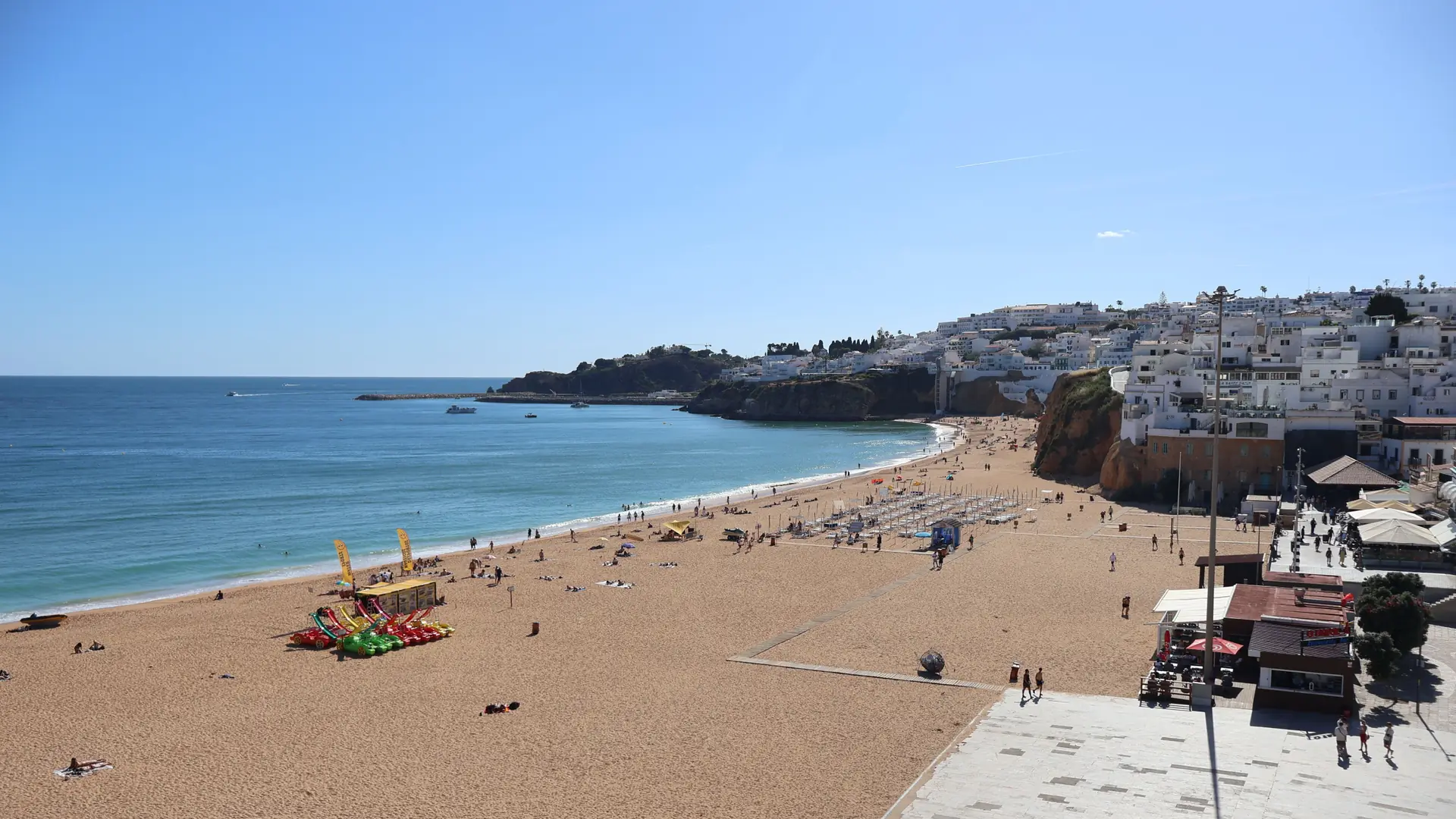 Praia dos Pescadores beach beneath Albufeira's white old town, vivid blue water