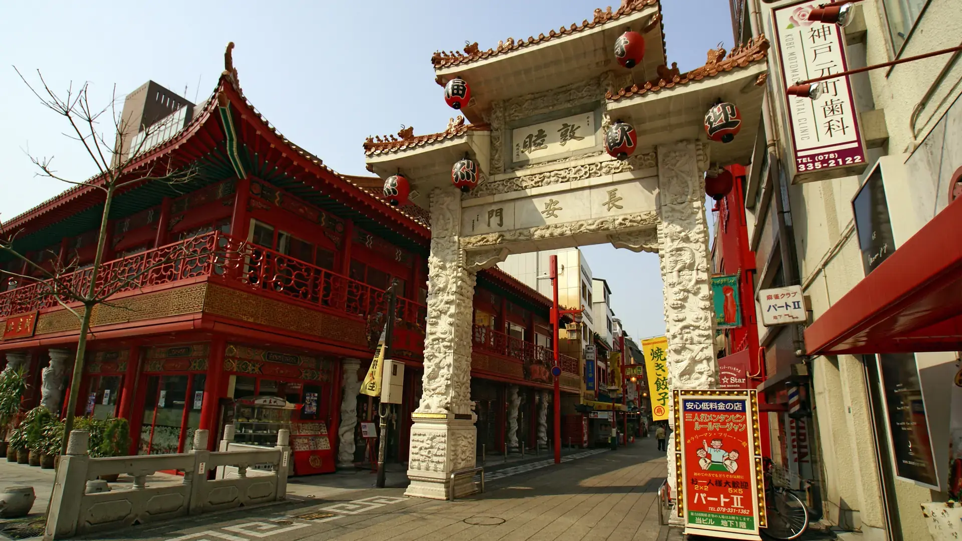 colourful Nankinmachi gate and lantern-lined Kobe Chinatown street under blue sky