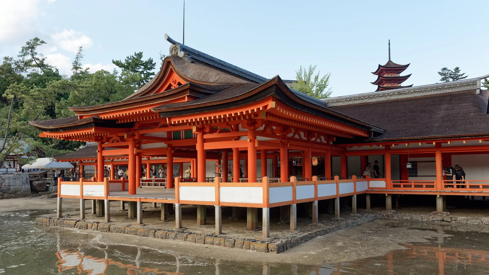 Itsukushima Shrine’s vermilion buildings reflected in shallow water on Miyajima