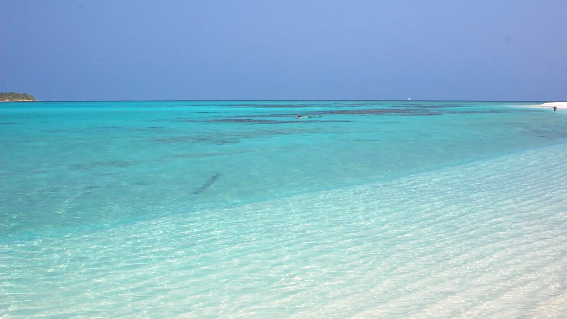 Clear sunlit lagoon and a white-sand edge off neighbouring Mathiveri, North Ari Atoll