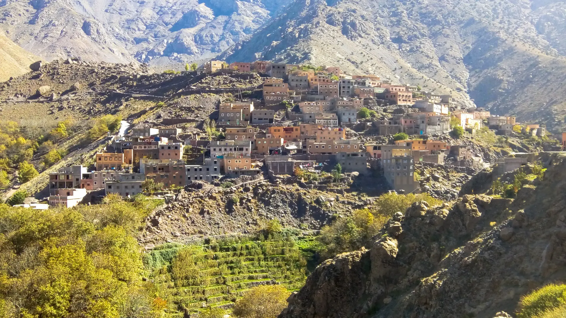 Sunny High Atlas valley above Imlil with green terraces and mountain ridges