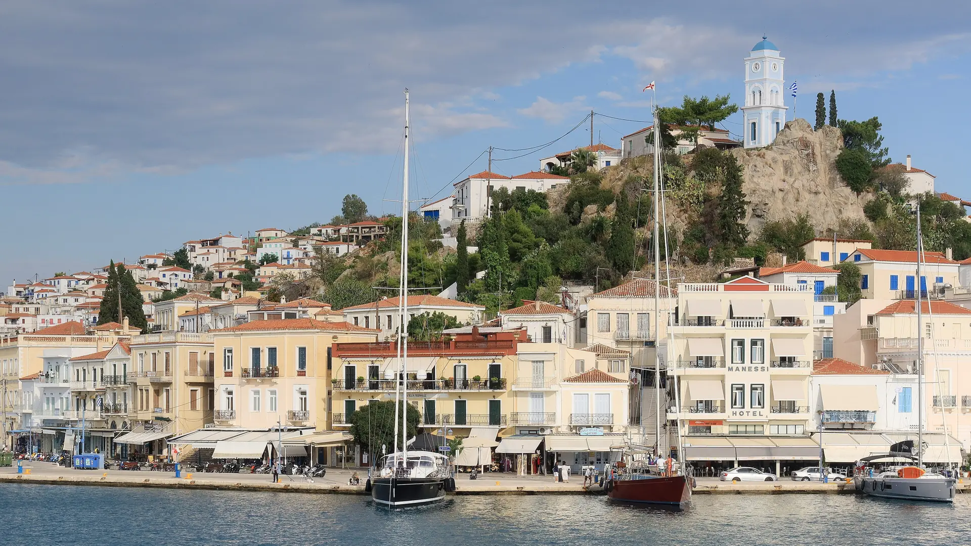 Poros waterfront with its white clock tower above pastel harbour houses
