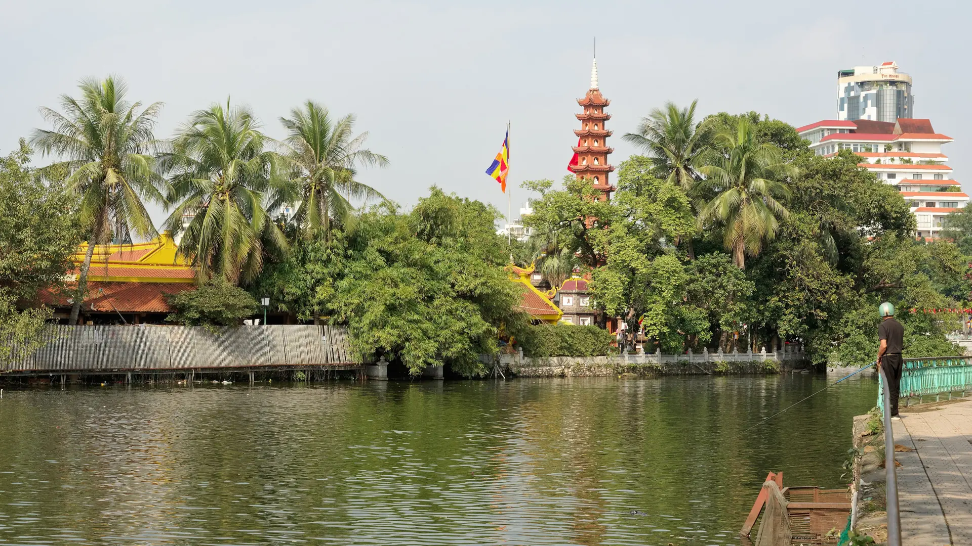 Tran Quoc Pagoda’s red tiered tower and palms beside Hanoi’s West Lake.