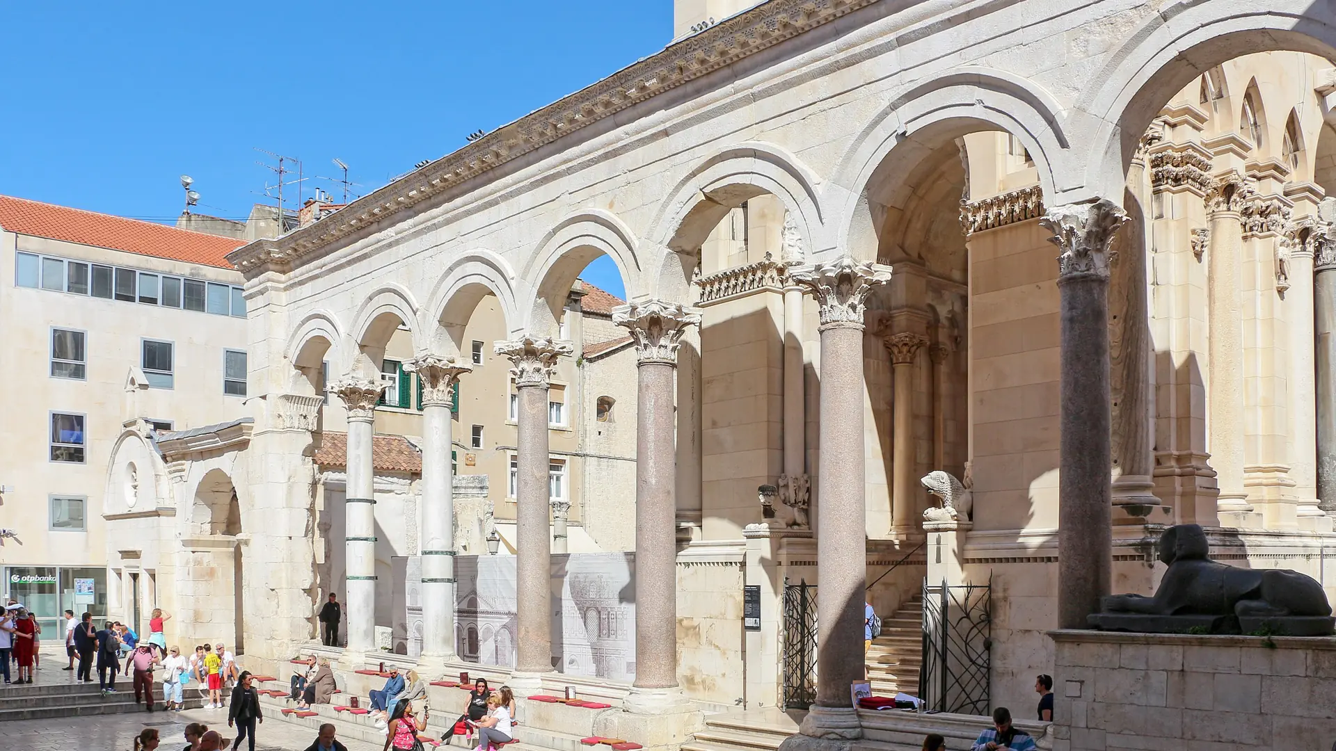 Split Peristyle in clear sunlight with ancient stone columns and pedestrians