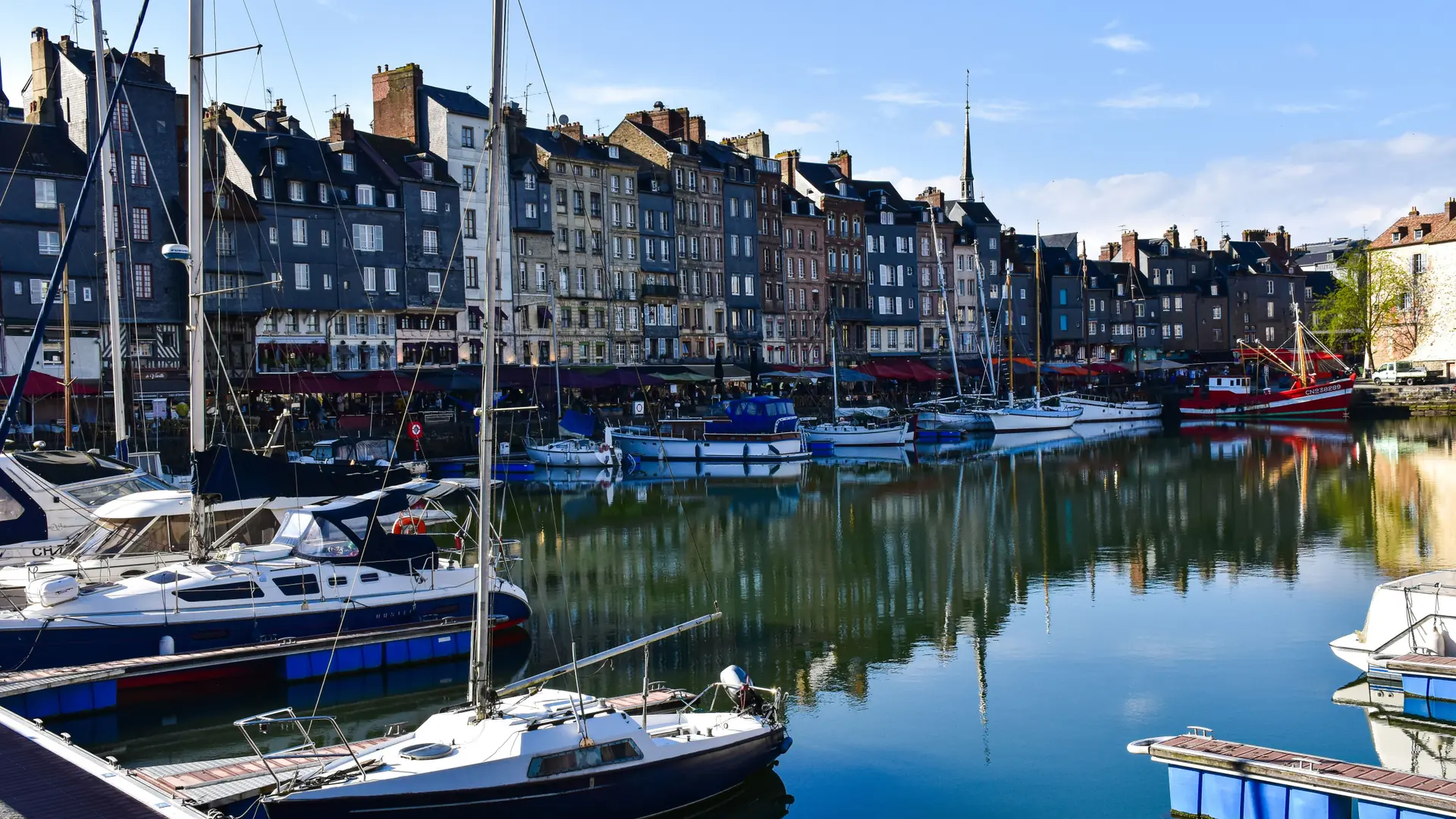Sailing boats and narrow historic houses reflected in Honfleur’s Vieux Bassin