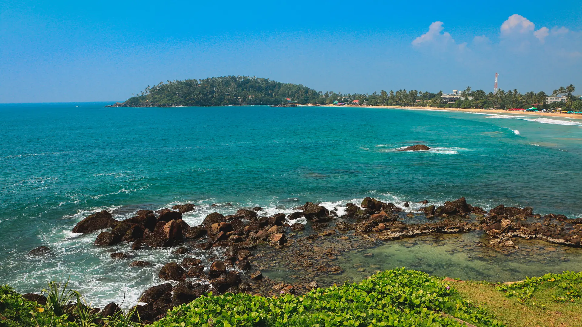 Rocky shore and turquoise water along Mirissa Beach