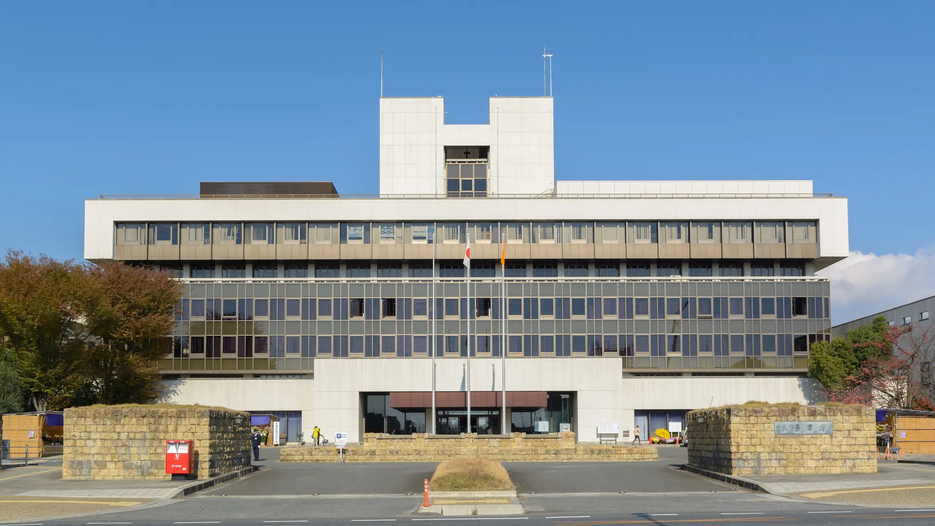Sunlit Nara City Hall and its entrance plaza west of Shin-Omiya Station under a clear blue sky