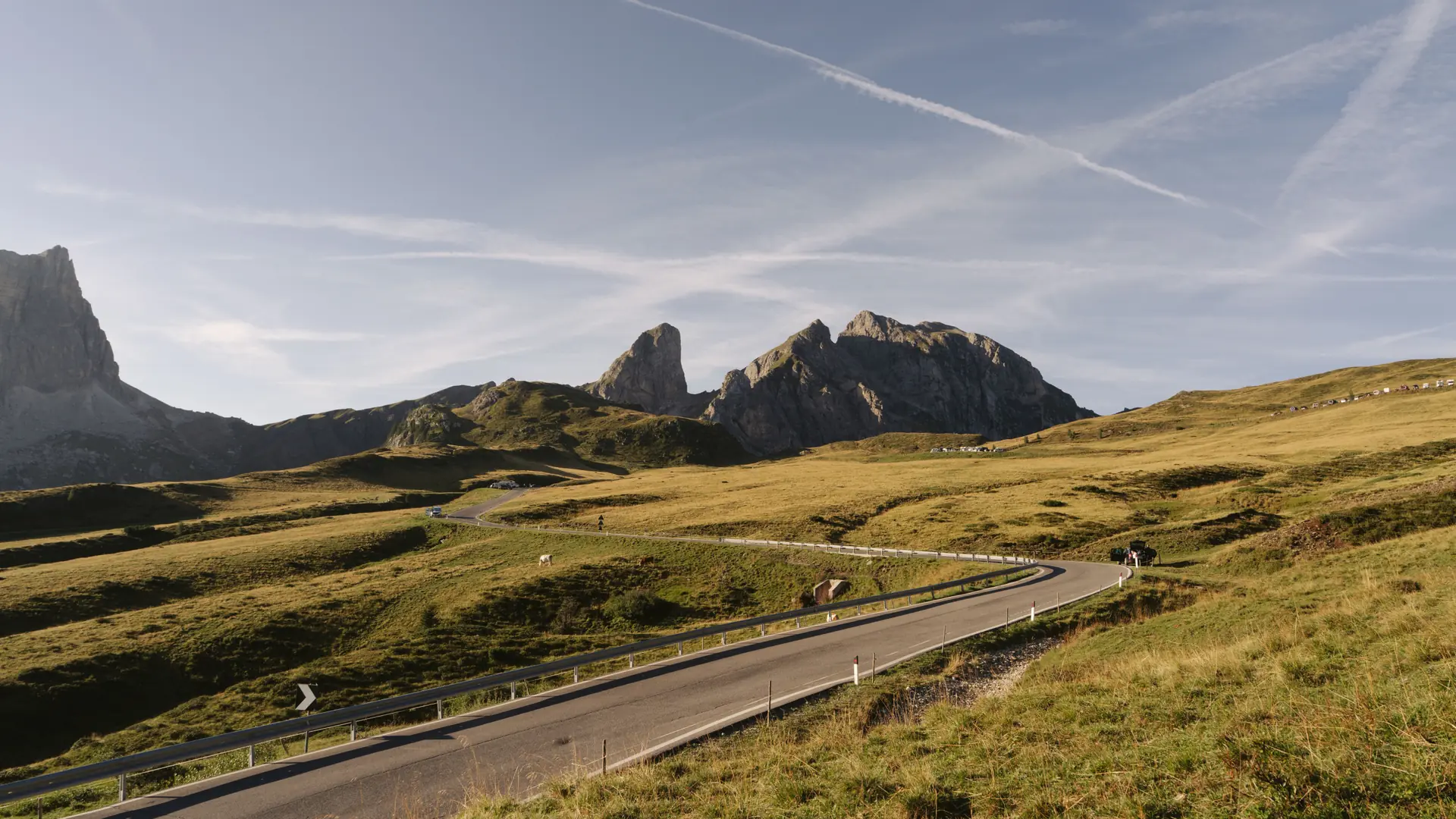 A winding mountain road beneath the jagged Dolomite peaks in northern Italy