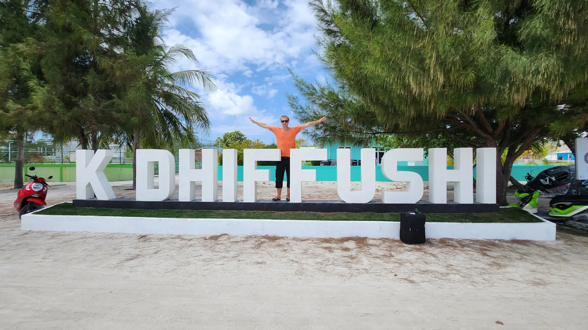 Welcome sign beneath trees on neighbouring Dhiffushi island