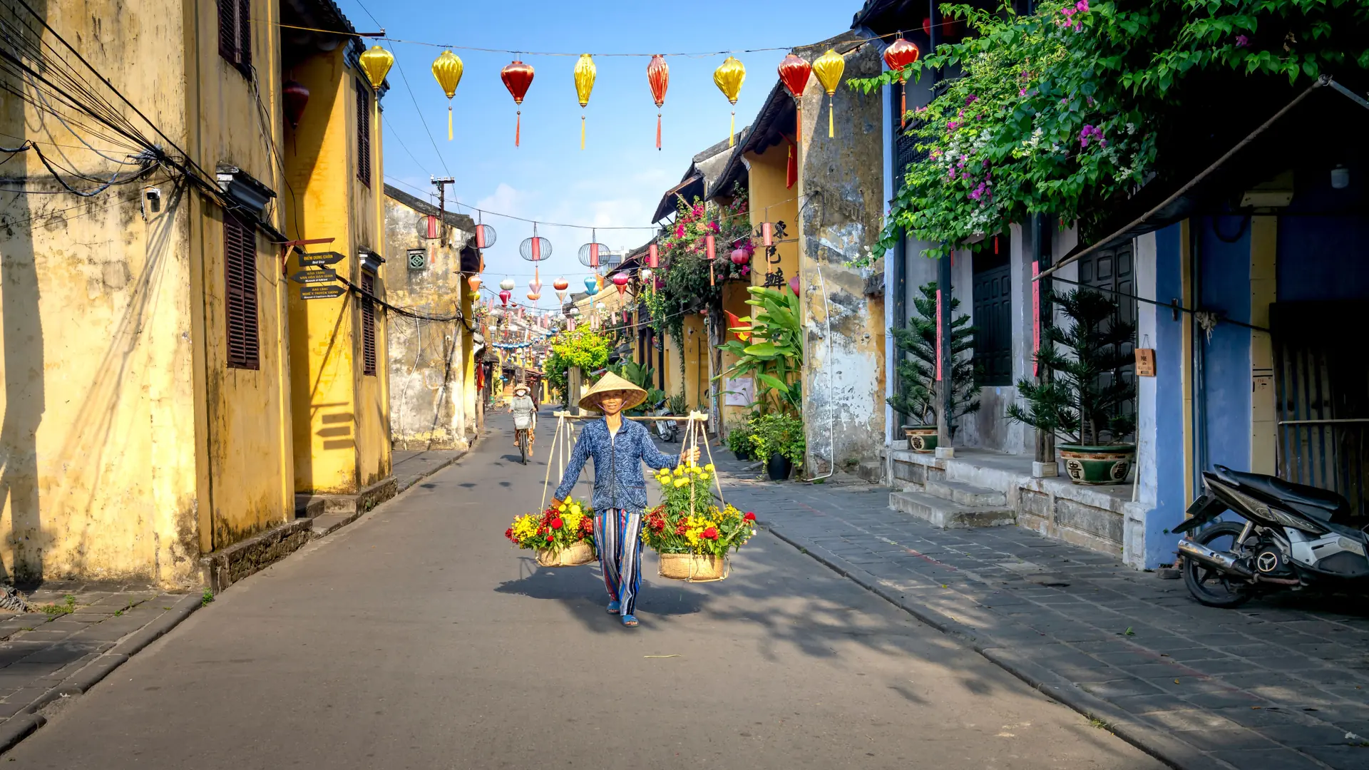 Yellow Hoi An facades beside a flower seller