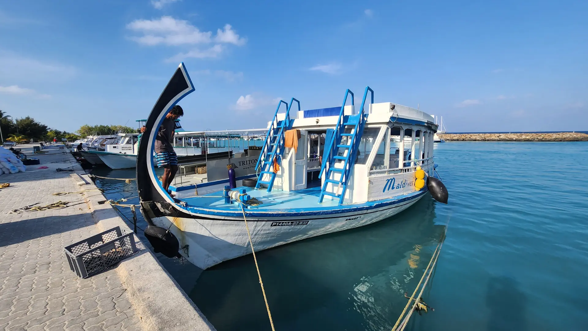 Blue dive boat moored beside a Maafushi quay