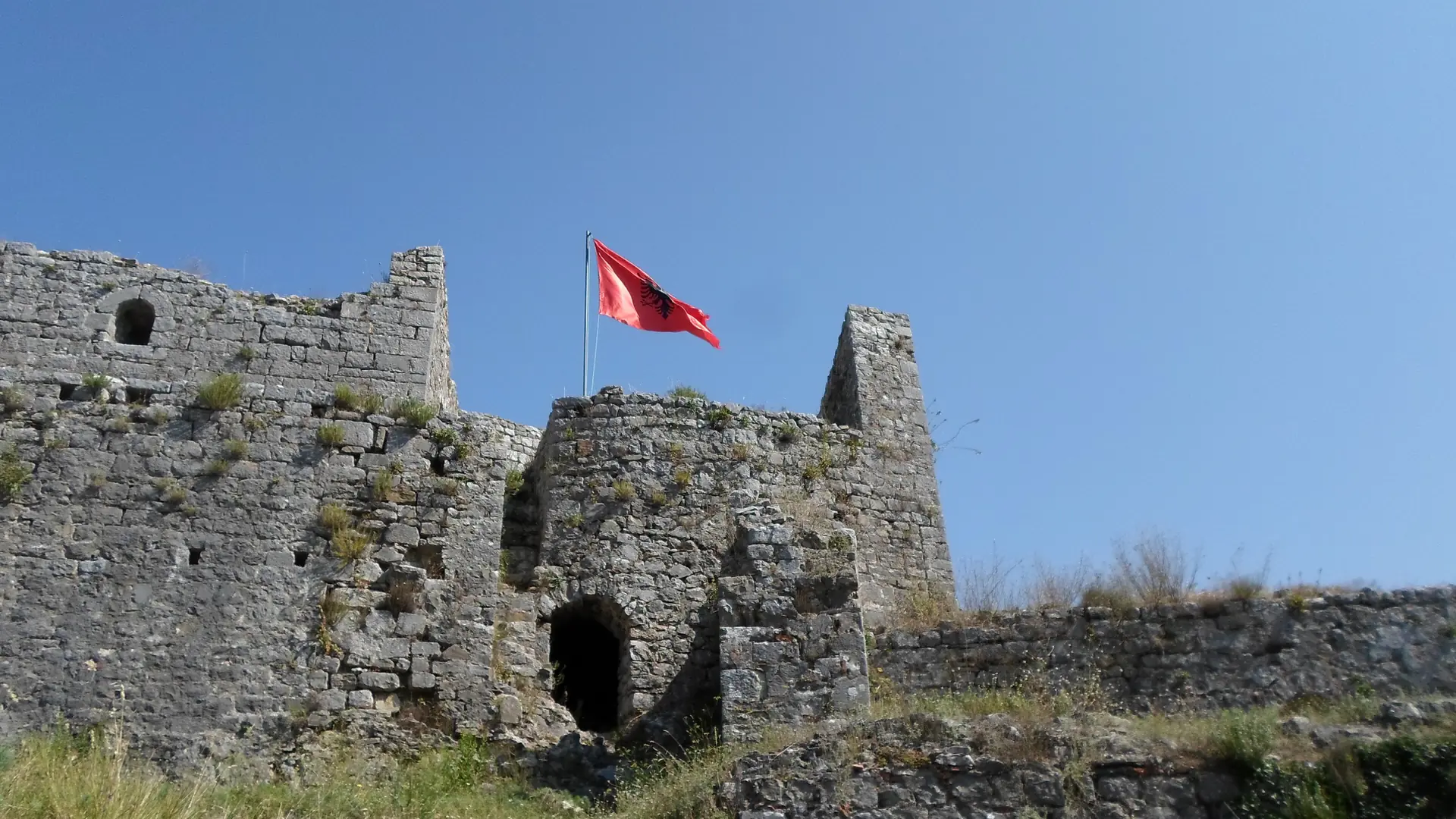 The stone walls of Rozafa Castle on its hilltop above Shkodër in bright sunshine