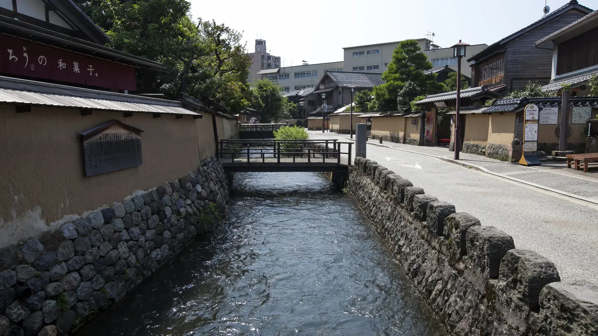 sunlit earthen walls and water channel in Kanazawa's Nagamachi samurai district