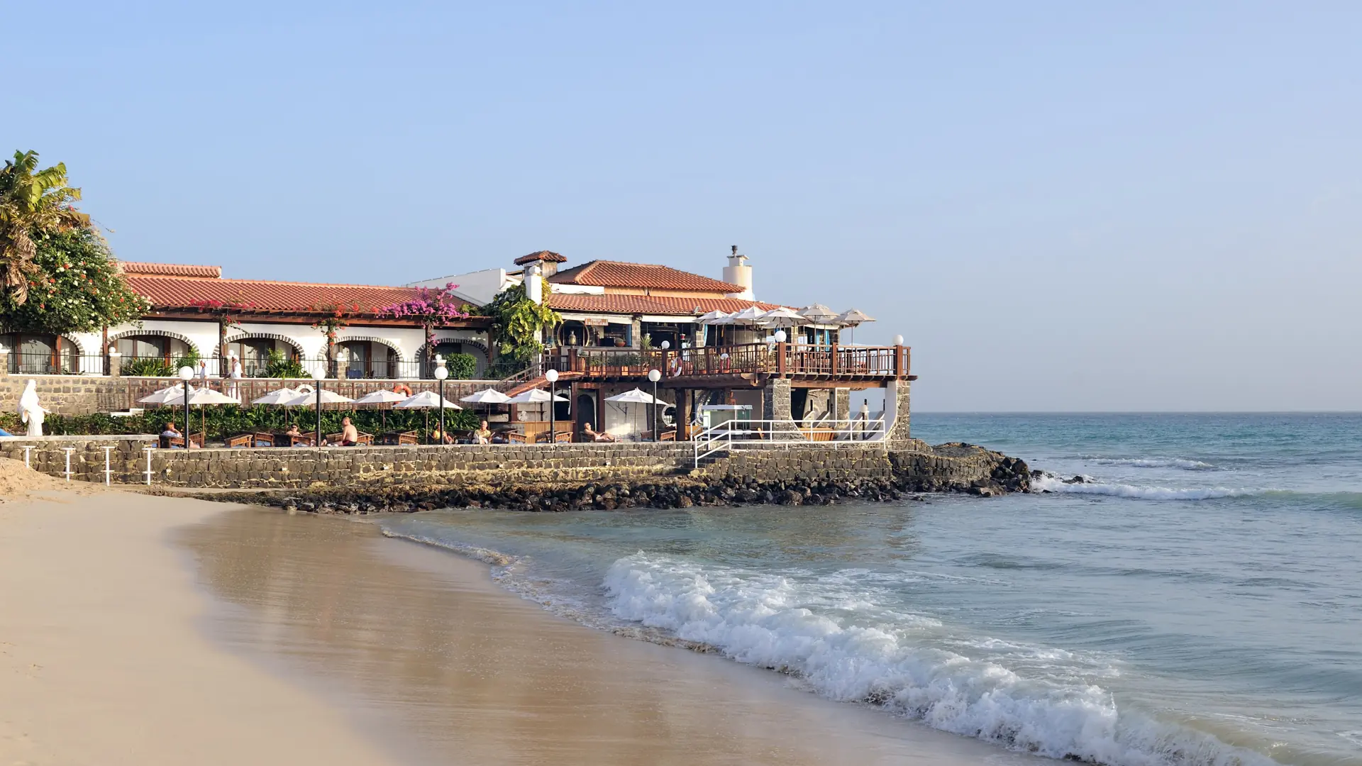 Sunlit Santa Maria beachfront café and Atlantic surf on Sal island