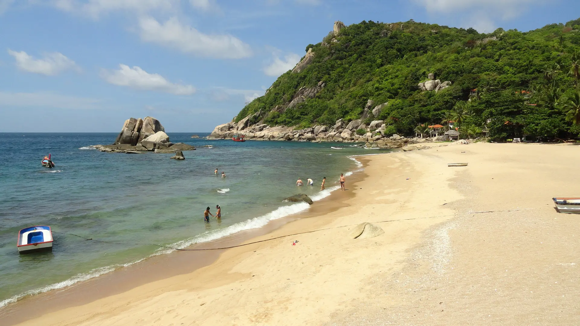 Clear turquoise water and a rocky green headland at Tanote Bay on Koh Tao