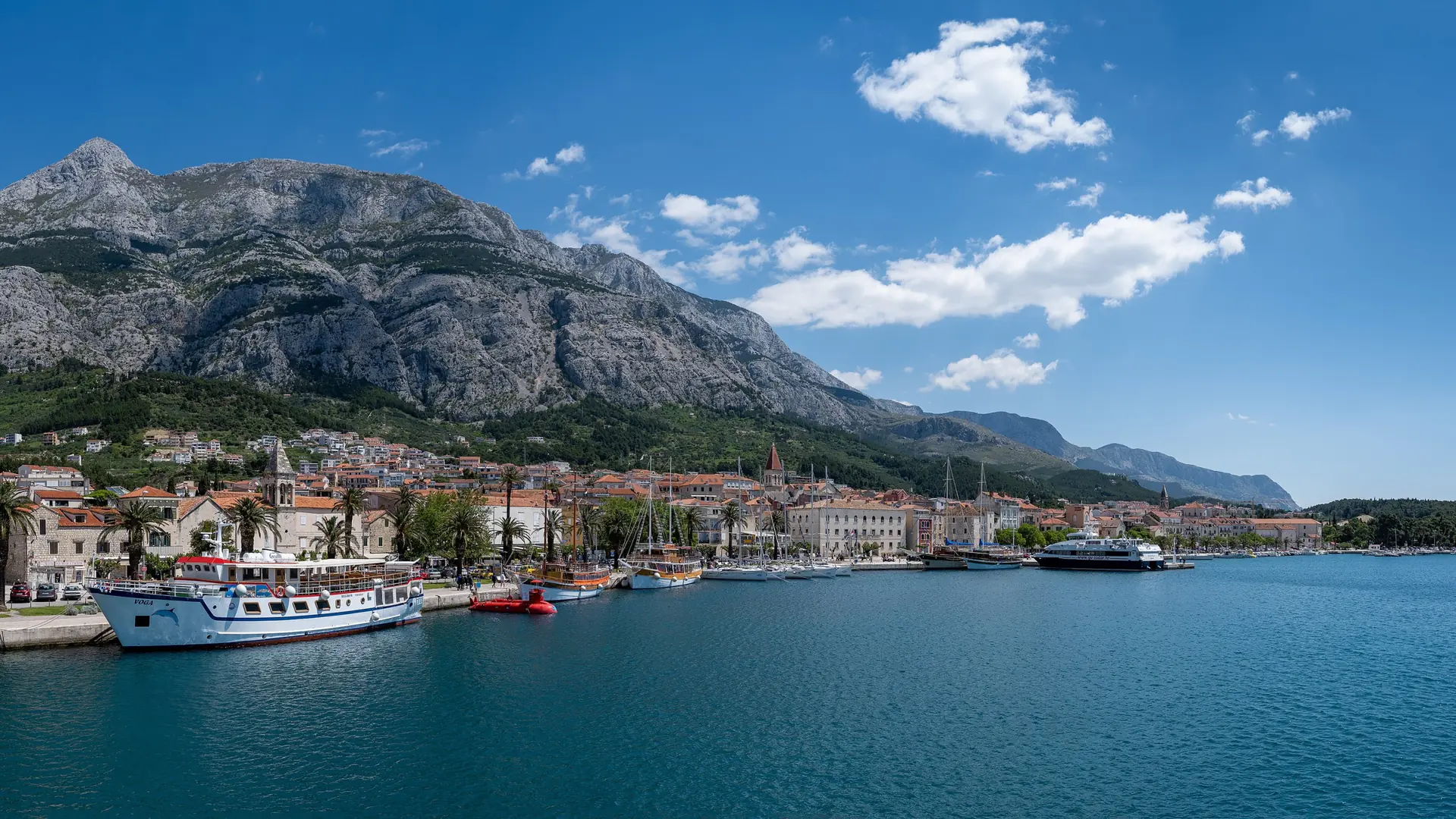 Makarska’s bright waterfront bay beneath the steep pale ridge of Biokovo