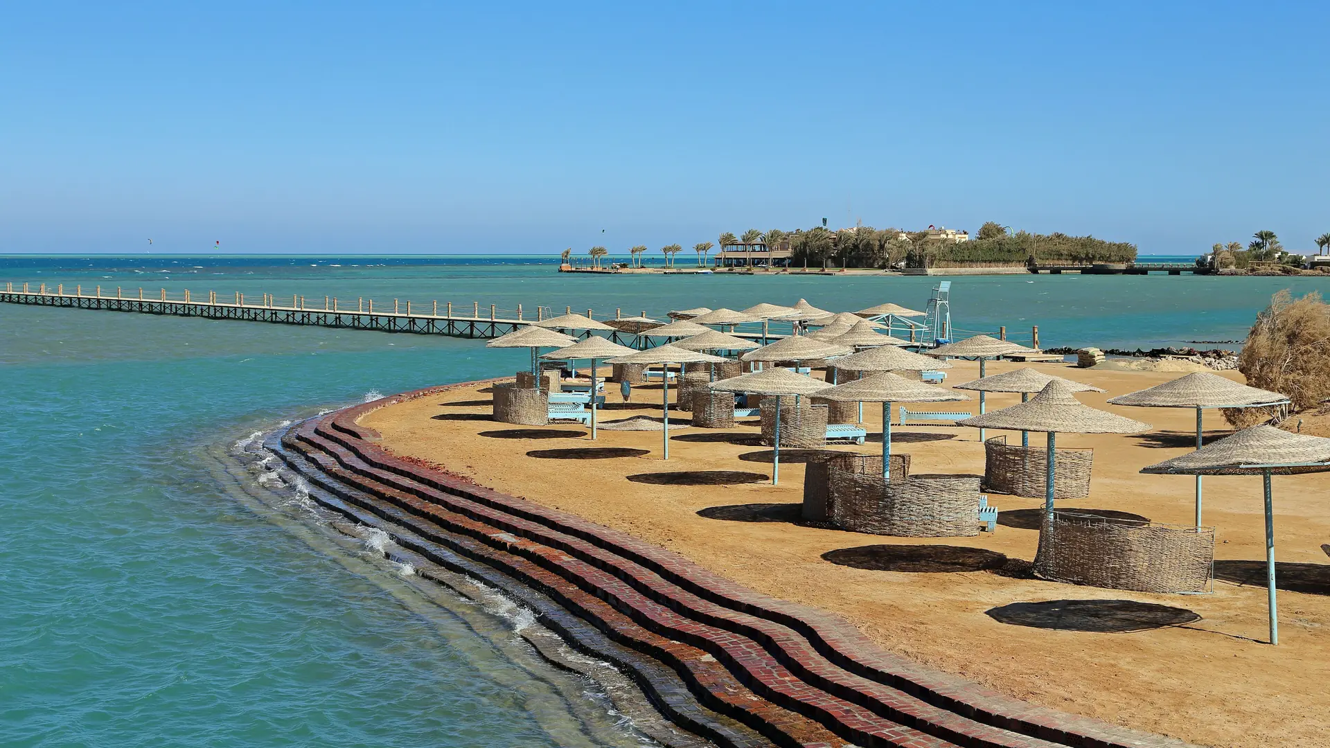 Straw parasols beside turquoise water on El Gouna’s Zeytouna Island beach